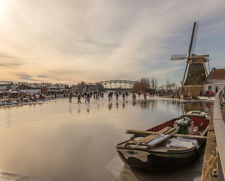 Des gens patinent près du moulin à vent de Schipluiden. par ChrisWillemsen