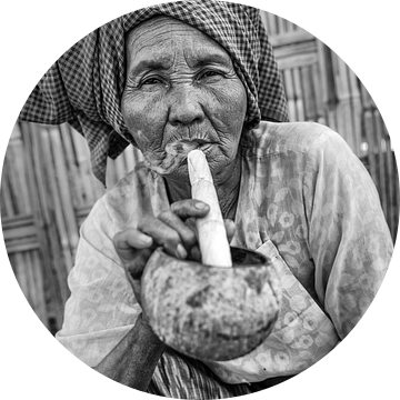 BAGHAN,MYANMAR, DECEMBER 12 2015 -Oude vrouw rookt de traditionele cheroot sigaar voor haar woning i van Wout Kok