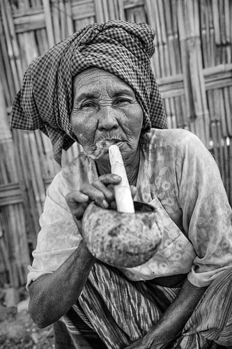 Alte Frau raucht traditionelle Stumpen Zigarre vor ihrem Haus in Baghan in Myanmar von Wout Kok