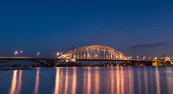 Waalbrug Nijmegen in de avond bij hoog water