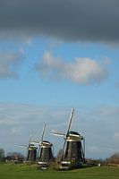 Drie molens met donkere lucht
