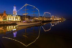 Abendlicher Blick auf die Skyline von Kampen am Fluss IJssel mit den klassischen Segelschiffen