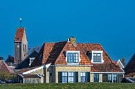 Kerktoren en huizen van het Friese stadje  Makkum achter de IJsselmeerdijk. van Harrie Muis thumbnail
