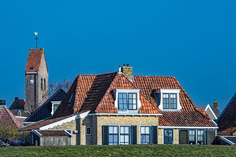 Kerktoren en huizen van het Friese stadje  Makkum achter de IJsselmeerdijk. van Harrie Muis