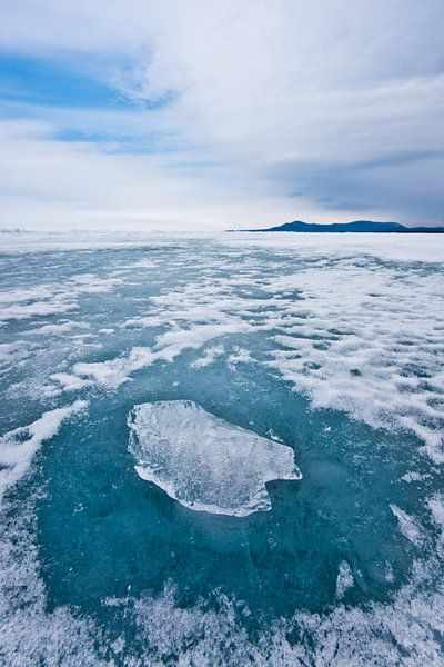 Een stuk doorzichtig ijs op een cirkel van doorzichtig blauw ijs op het ijs van het baikalmeer, berg van Michael Semenov