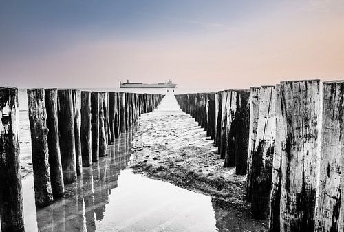 Wellenbrecher im Meer bei Ebbe in Zoutelande, Zeeland, Schiff segelt vorbei