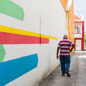 Mann mit gestreiftem Hemd und farbenfroher Wandmalerei, Otrobanda, Curacao von Paul van Putten