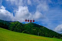 Rote Gondeln in den Bergen unter strahlend blauem Himmel
