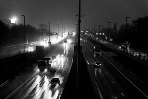 Ochtendspits in het donker op de snelweg, bij sneeuwval