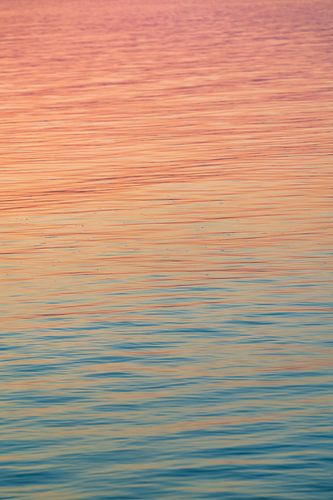 Rainbow colours in the water at sunset. At Lake Balaton in Hungary with calm water