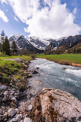Rocks, flowing river and Swiss mountains