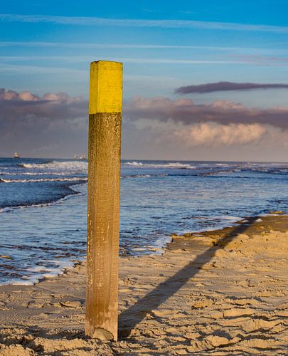 Strandpaal in het laatste avondlicht