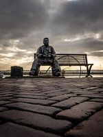Beeld de visser op klompen, zittend op een bank in Volendam - Nederland.
