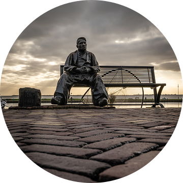 Beeld de visser op klompen, zittend op een bank in Volendam - Nederland. van Jolanda Aalbers