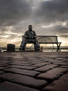 Statue eines Fischers auf Holzschuhen, der auf einer Bank in Volendam - Niederlande - sitzt.