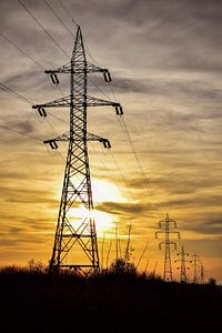 Elektrische zonsondergang - Powerline-silhouetten in de zon van Andreea Eva Herczegh