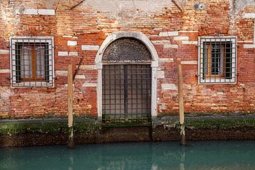 Deur met hekwerk aan kanaal in oude centrum Venetie, Italie