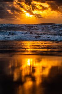 Reflexion der untergehenden Sonne auf dem Strand von Noordwijk