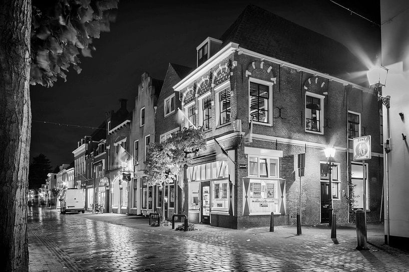 Un bâtiment historique au coin de la Utrechtsestraat Hofstraat la nuit en noir et blanc par Tony Buijse