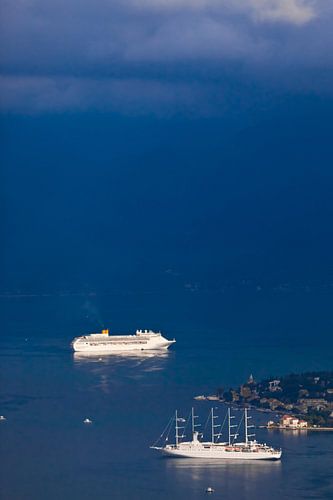 far in the blue distance, the sea mixes with clouds two ships in the bright blue sea and a little gi