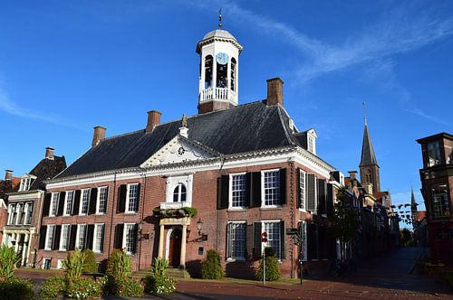 Zicht op stadhuis van Dokkum, Friesland. Begin van de herfst, licht verkleurde bladen aan de bomen, op een zonnige dag.