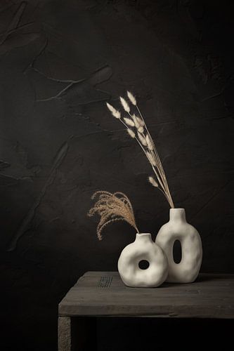 Nature morte sombre avec des fleurs séchées dans des bocaux blancs sur Mayra Fotografie
