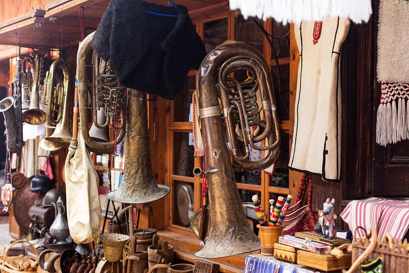 sfeerbeeld van oude trompet hanged voor de ruit van een winkeltje by Giovanni de Deugd