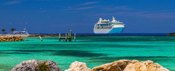 Een groot cruiseschip ligt aangemeerd naast een tropisch eiland. van Yevgen Belich