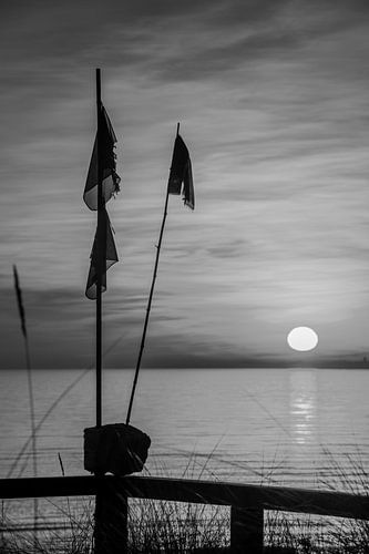 Vissersboei op het strand van de Oostzee bij zonsopgang. Zwart-wit Bi