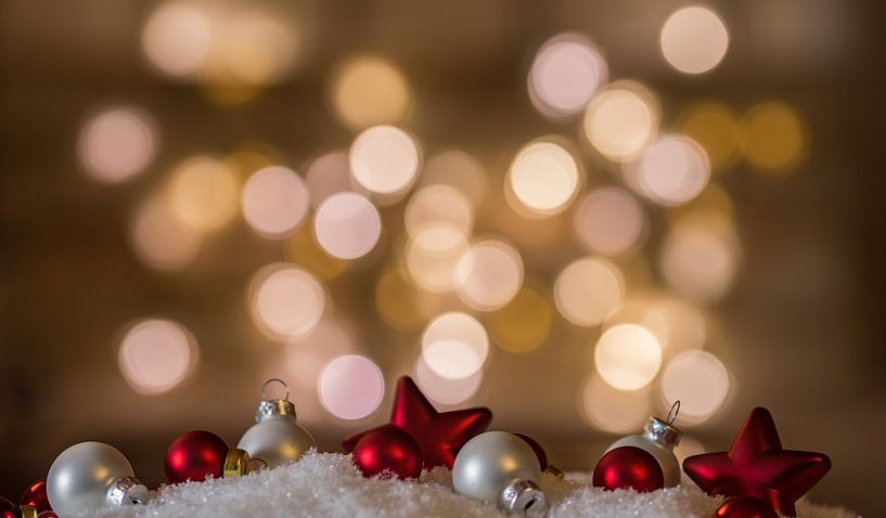 Red and white christmas decorations on snow by Alex Winter