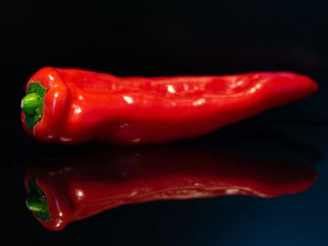 Dot bell pepper on black mirror background by Arjan van der Veer