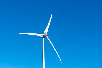 Windturbine met draaiende wieken met een strakblauwe lucht in de b van Sjoerd van der Wal