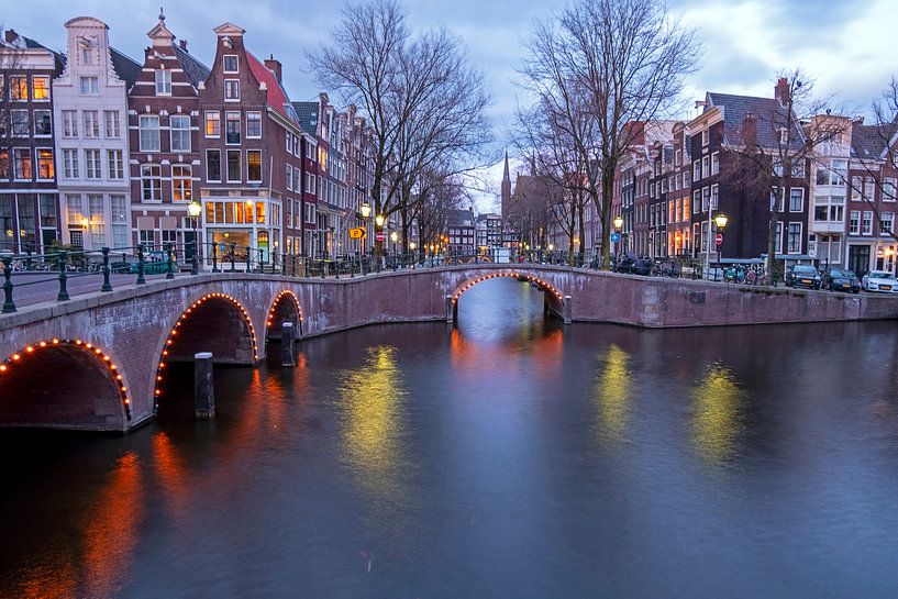 Stadsgezicht van Amsterdam in Nederland bij avond van Eye on You