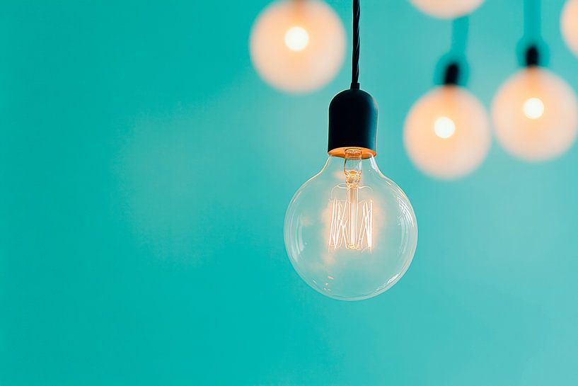 Hanging light bulb against a blue background by Poster Art Shop