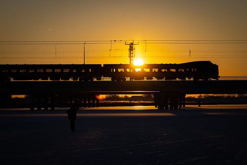 De zon schijnt door de Koploper trein heen op de Hanzelijn
