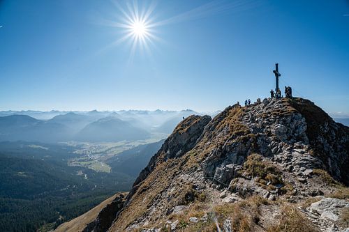 Klimmer op de top van de Aggenstein met uitzicht op het Tannheimer Tal en de Allgäuer Alpen, zoals de Hochvogel