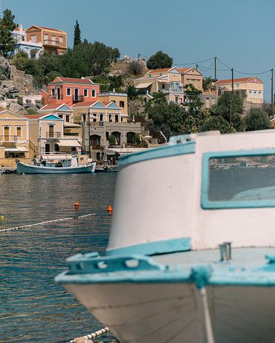 Griekse boot met de typische huisjes van Symi op de achtergrond