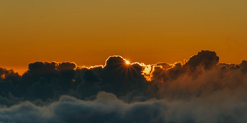Golden sunset above a sea of clouds – Sunstar panorama