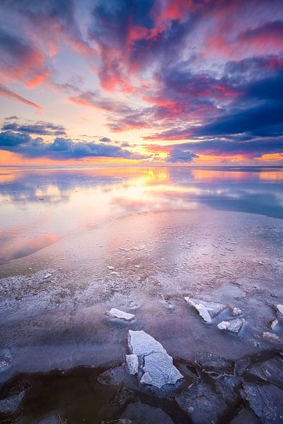 Winter landschap op het IJsselmeer bij Workum in Friesland met een kleurrijke zonsondergang. van Bas Meelker