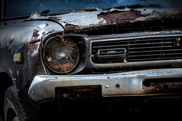 Een verlaten geroeste oldtimer Datsun 120y uit 1973