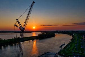 Une grue de levage contribue au lever du soleil