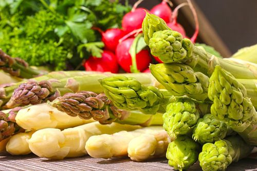 Green asparagus and white asparagus decorated on a rustic wooden table