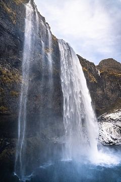 Seljalandsfoss in Iceland with yellow moss and blue water by Mickéle Godderis