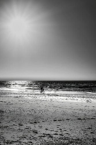 Minimalisme van het strand met eenzame fietser van eric van der eijk