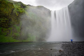 Iceland - Skogafoss waterfall with person arms stretched wide by adventure-photos