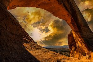 Sonnenuntergang mit Bewölkung hinter Steinbogen im Arches Nationalpark Utah USA