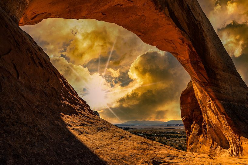 Sunset with clouds behind stone arch in Arches National Park Utah USA by Dieter Walther