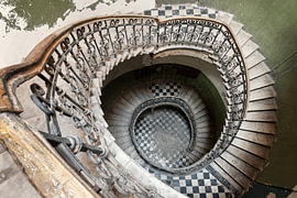 Wendeltreppe mit Ziergeländer in verlassener Villa von Times of Impermanence