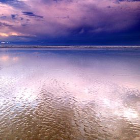 Lila Wolken spiegeln sich am Strand von Iris Lok