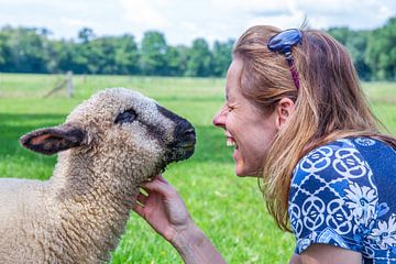 Woman and sheep heads together by Ben Schonewille